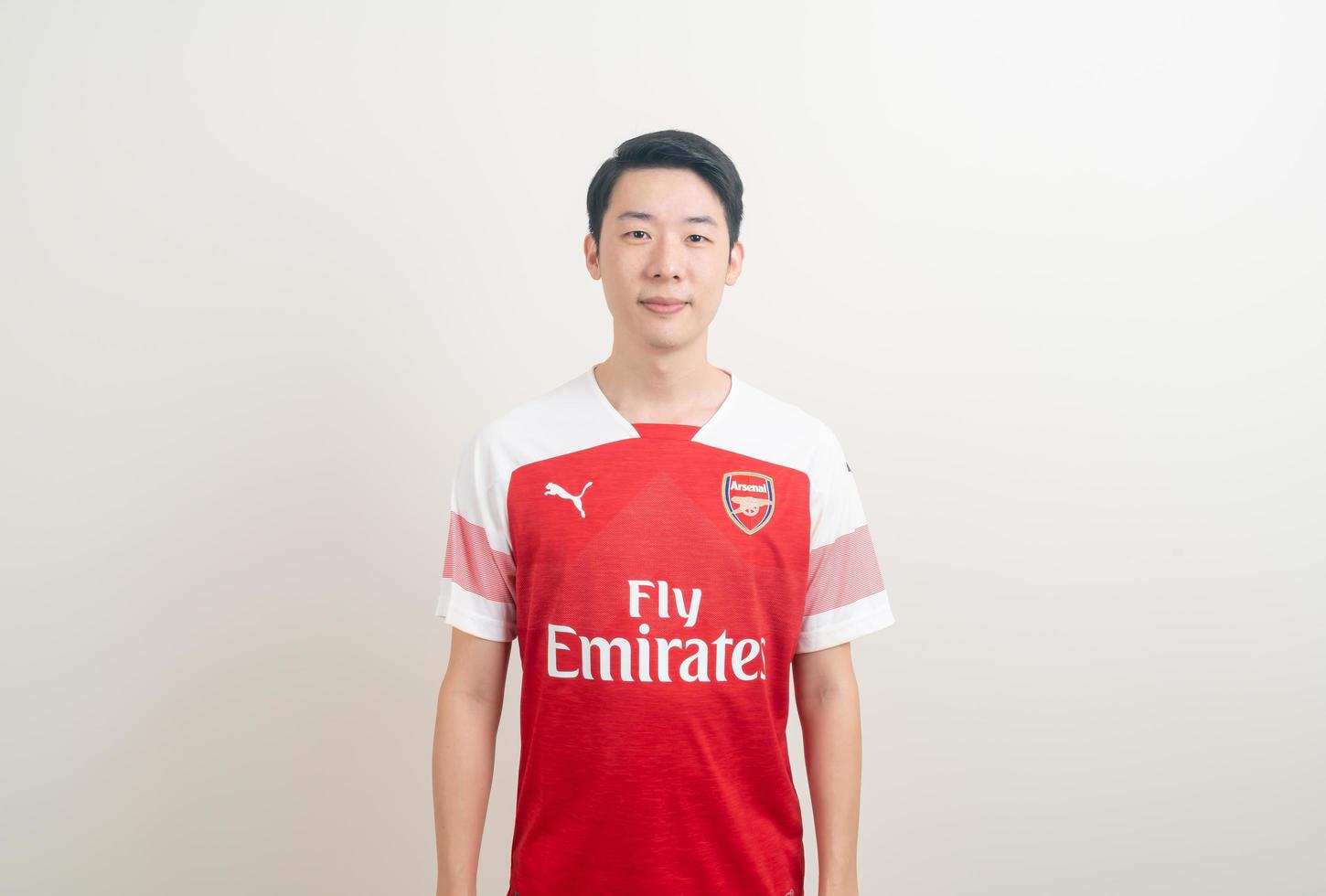 Bangkok, Tailandia - 27 de noviembre de 2021 - joven asiático vistiendo la camiseta del arsenal con fondo blanco. foto