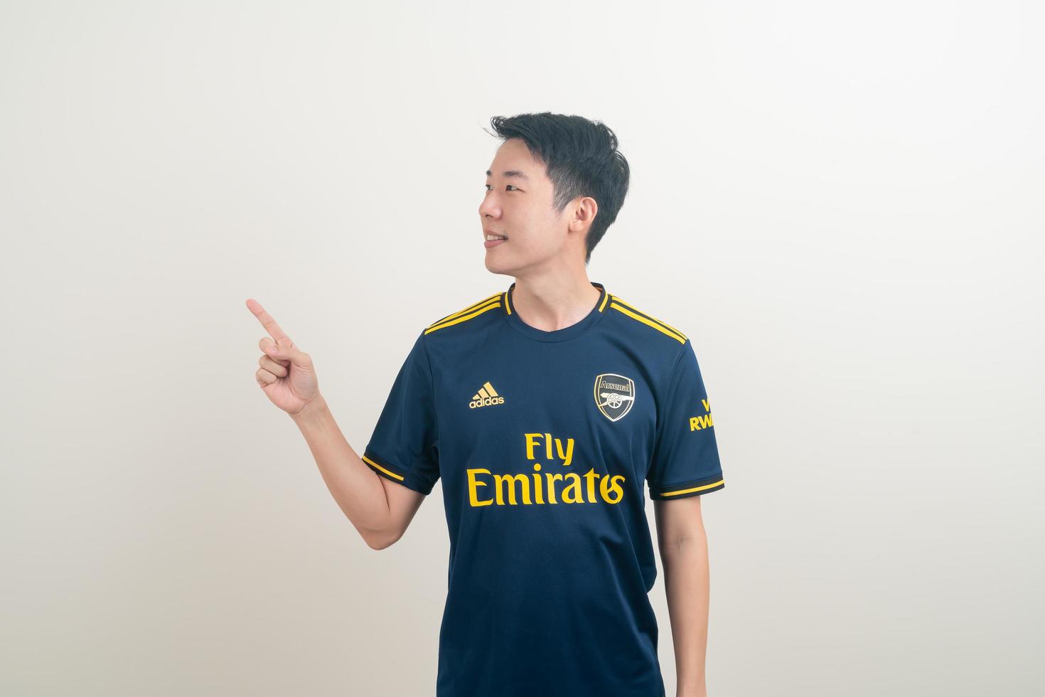 Bangkok, Tailandia - 27 de noviembre de 2021 - joven asiático vistiendo la camiseta del arsenal con fondo blanco. foto