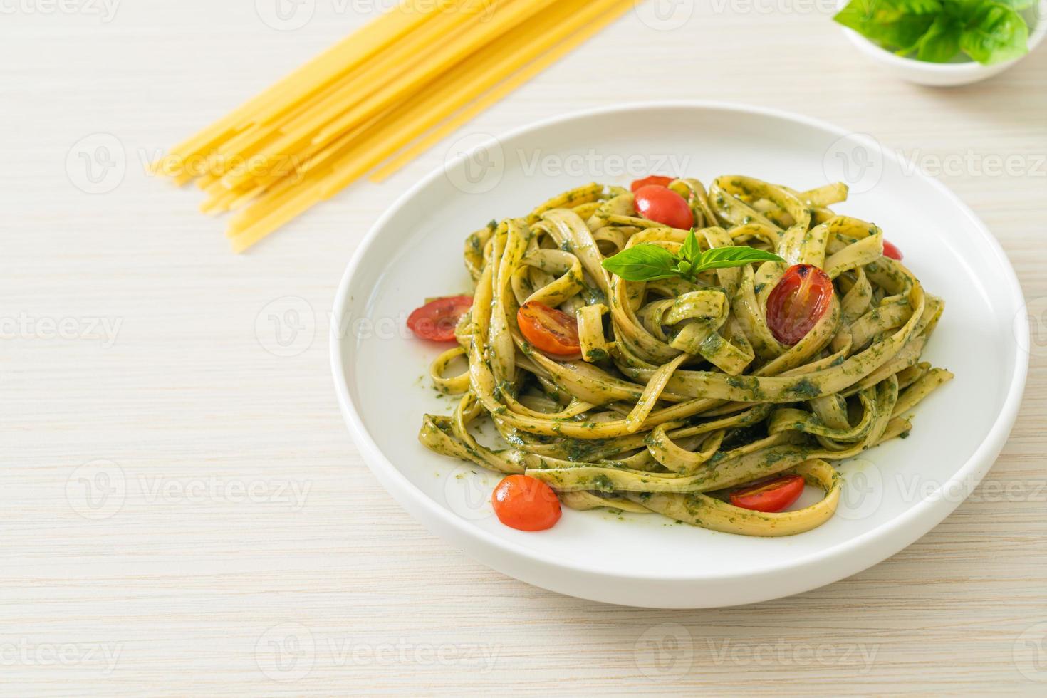 fettuccine spaghetti pasta with pesto sauce and tomatoes photo