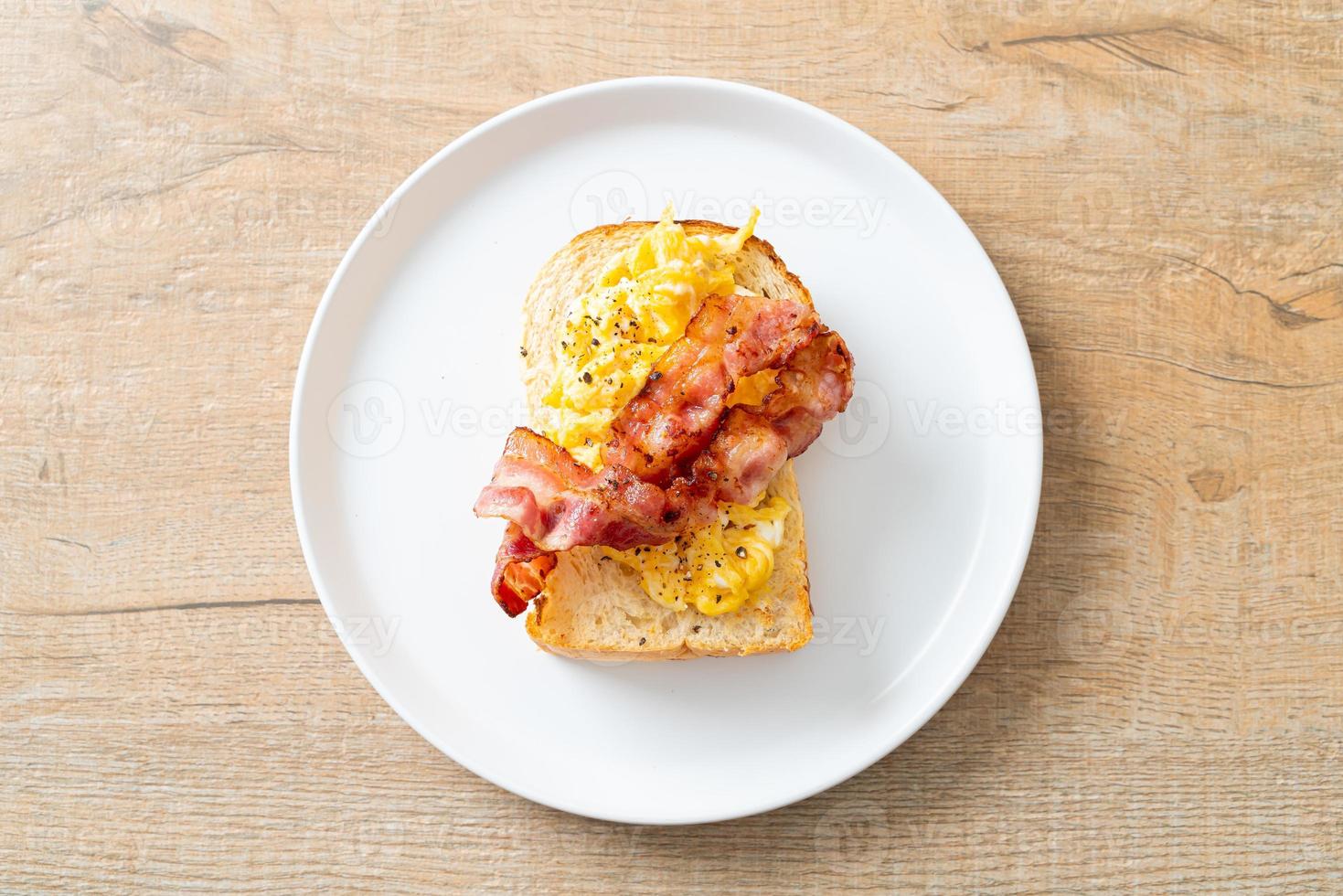 tostada de pan con huevos revueltos y tocino foto