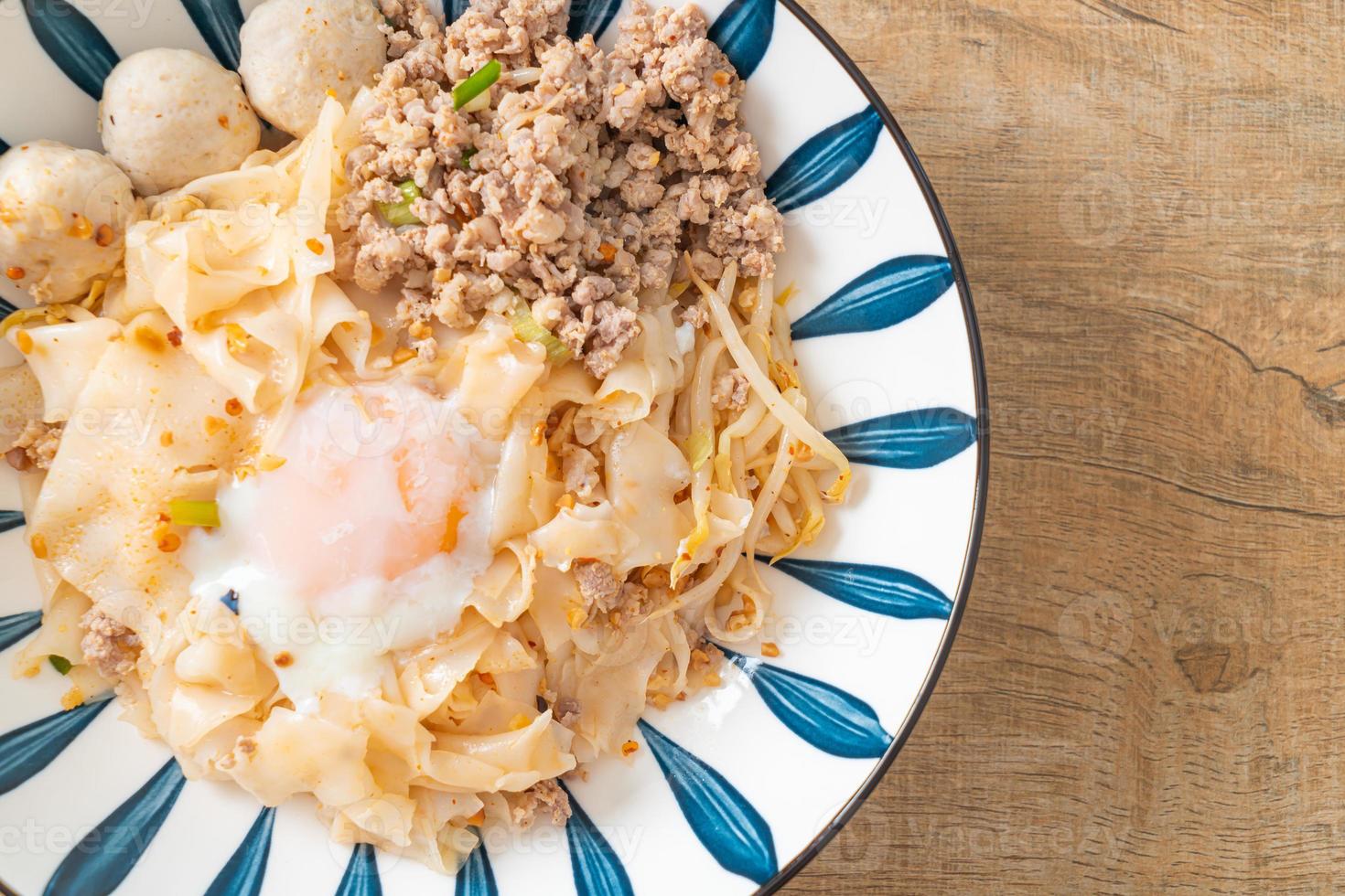 dried spicy noodles with minced pork, meatballs and egg photo
