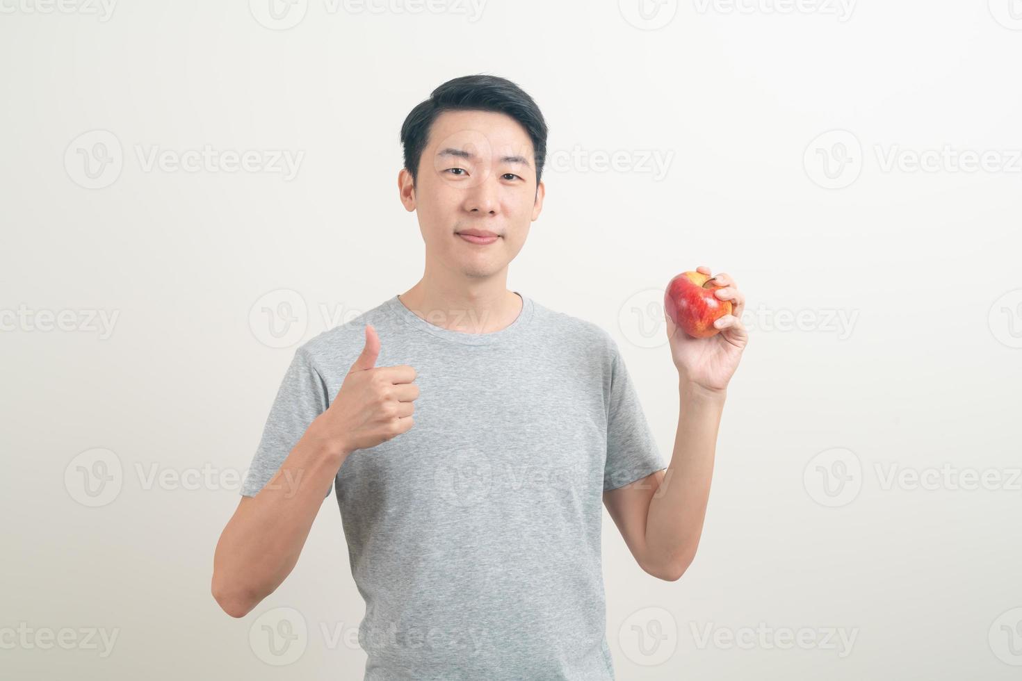 young Asian man with glass of water and apple on hand photo