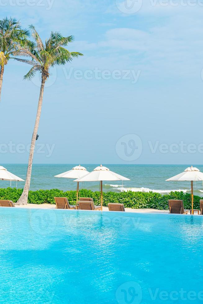 umbrella with bed pool around swimming pool with ocean sea background photo