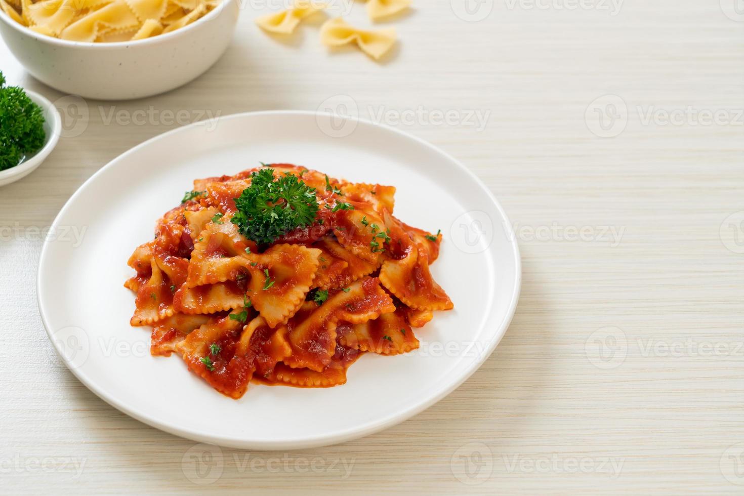 farfalle pasta in tomato sauce with parsley photo