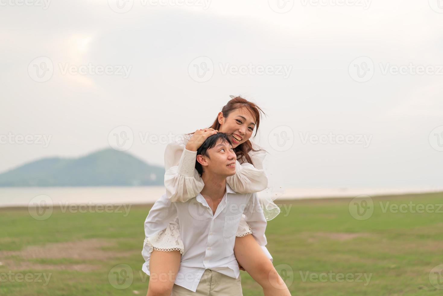 Happy young Asian couple in bride and groom clothing photo