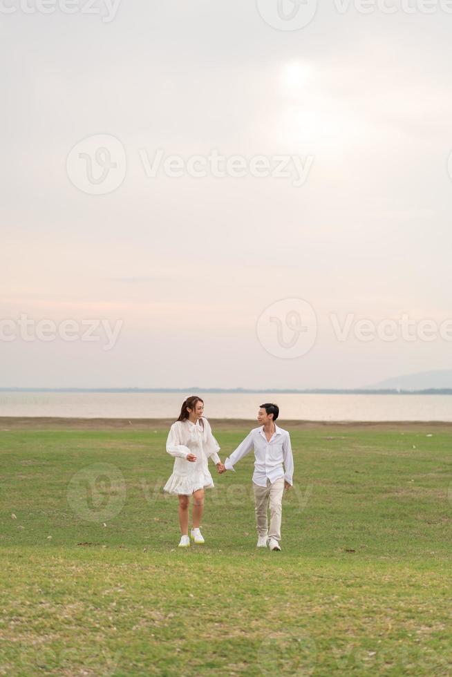 Happy young Asian couple in bride and groom clothing photo