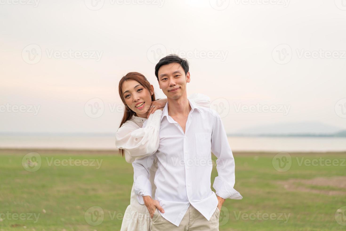 Happy young Asian couple in bride and groom clothing photo