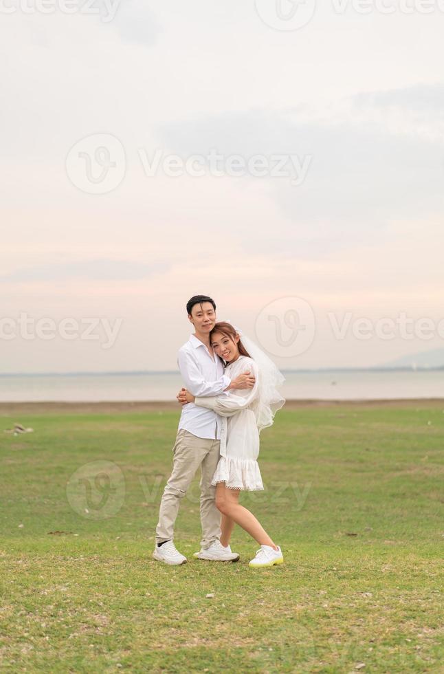 Happy young Asian couple in bride and groom clothing photo