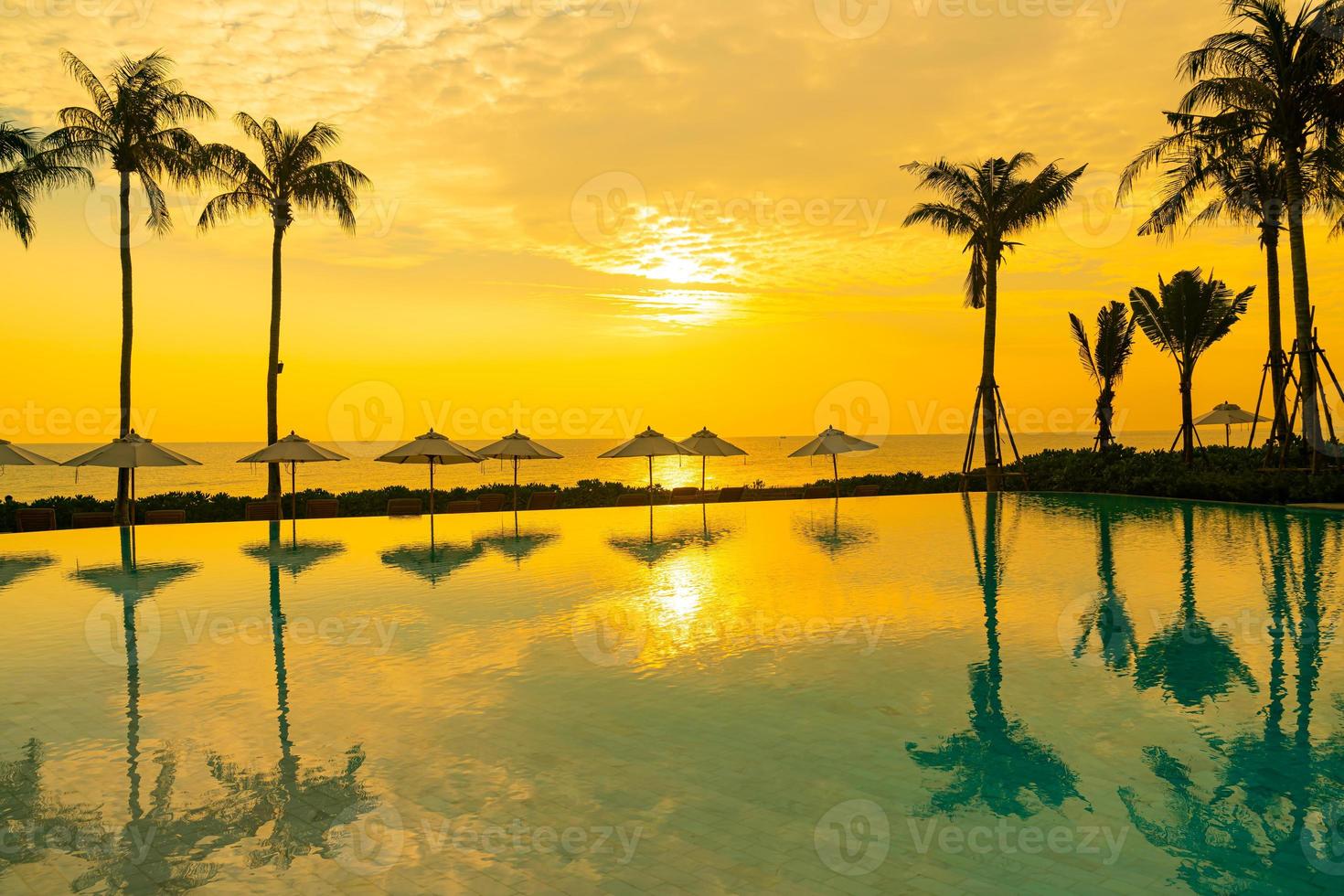 umbrella with bed pool around swimming pool with ocean sea background photo