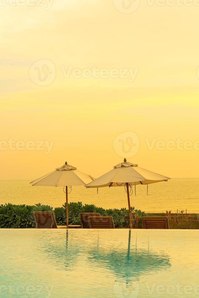 umbrella with bed pool around swimming pool with ocean sea background photo