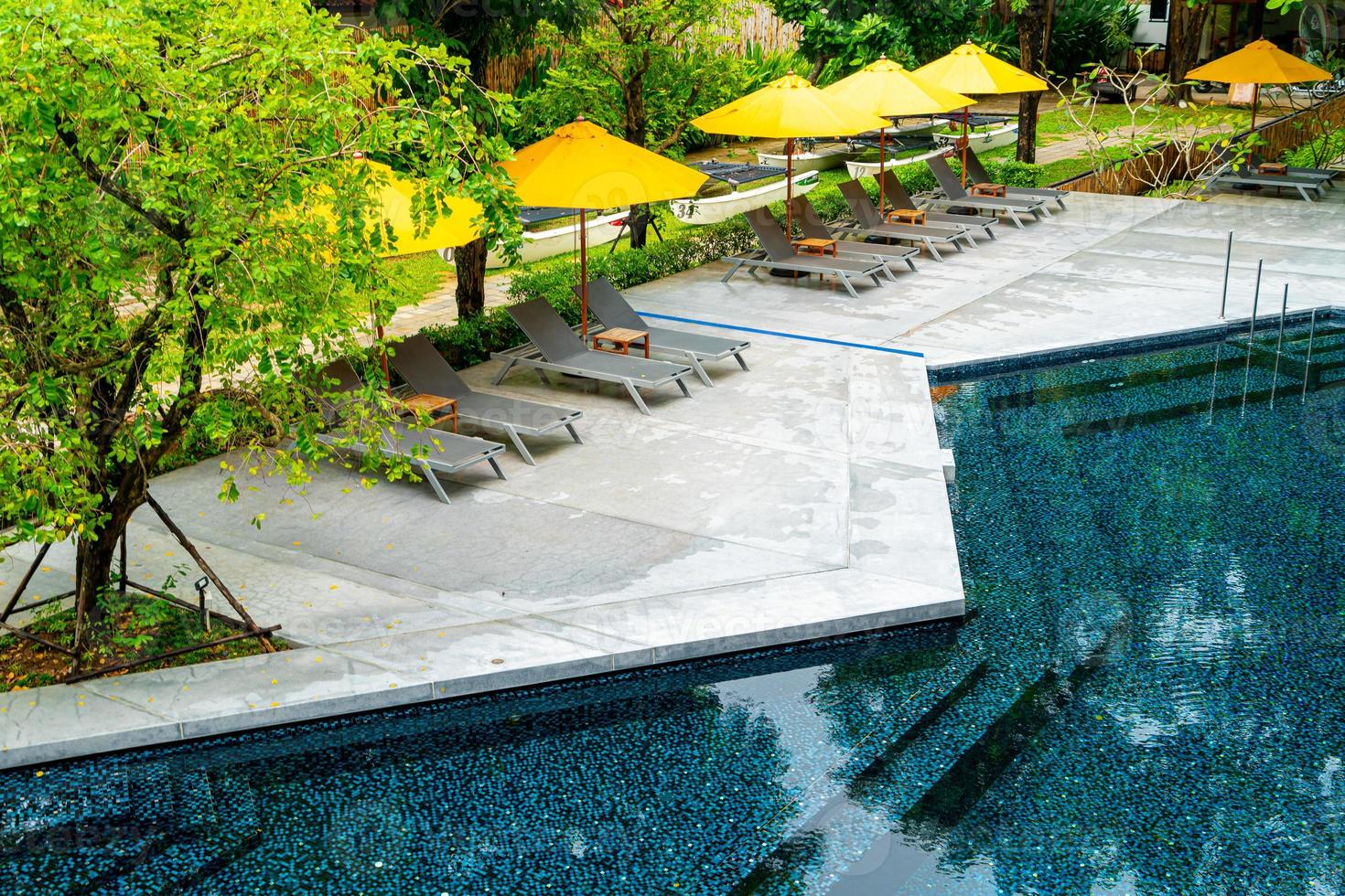 sombrilla y cama de piscina alrededor de la piscina foto