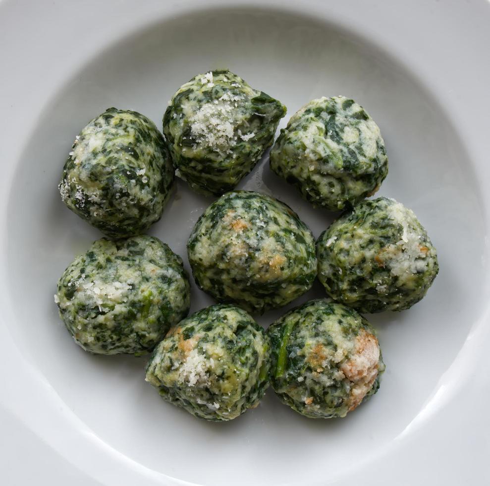 Italian Gnudi are a typical first course dish of Tuscan cuisine. Gnudi are large gnocchi made with ricotta, spinach, Parmigiano Reggiano cheese, but without pasta. photo