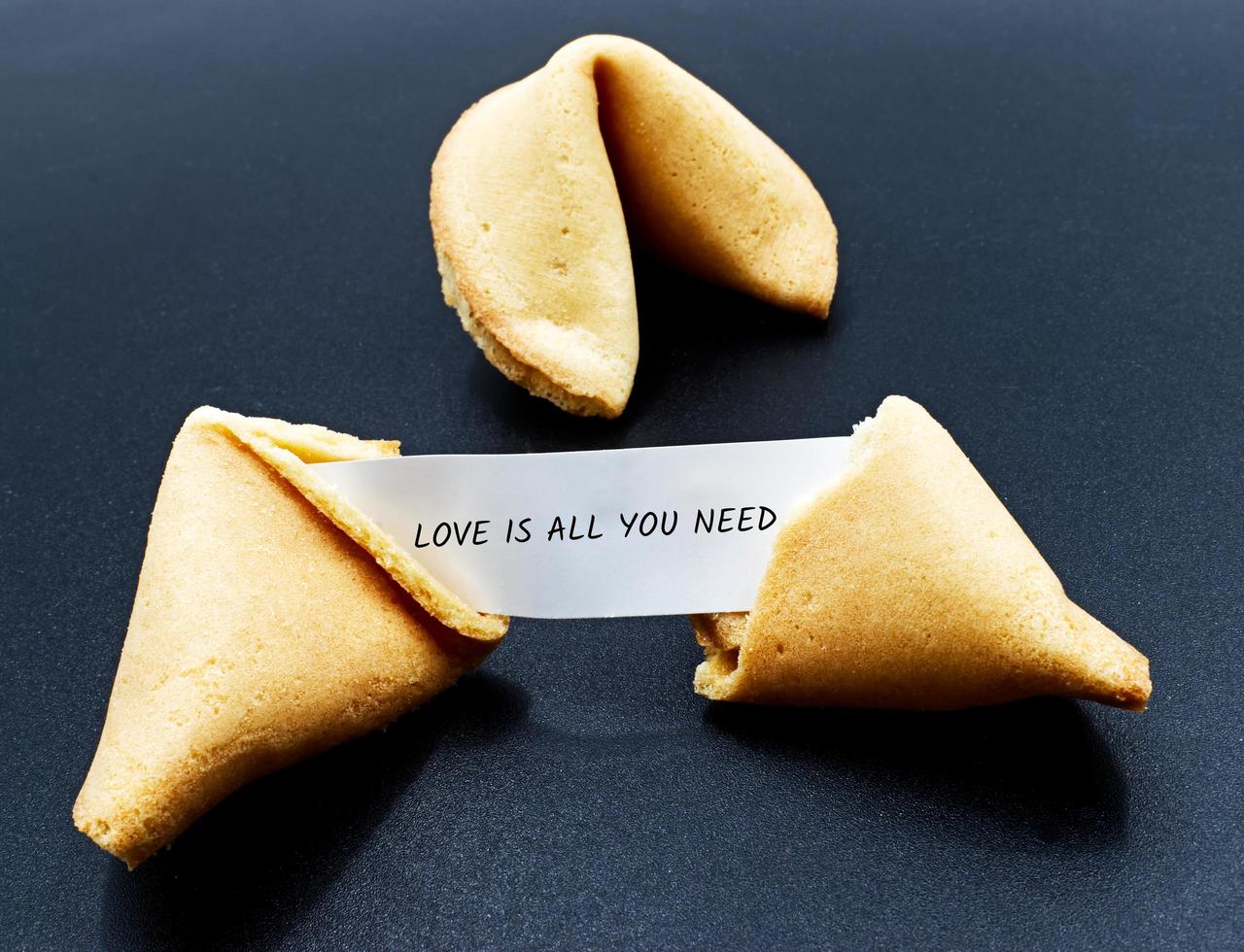 el amor es todo lo que necesitas. cita motivacional en una galleta china rota foto