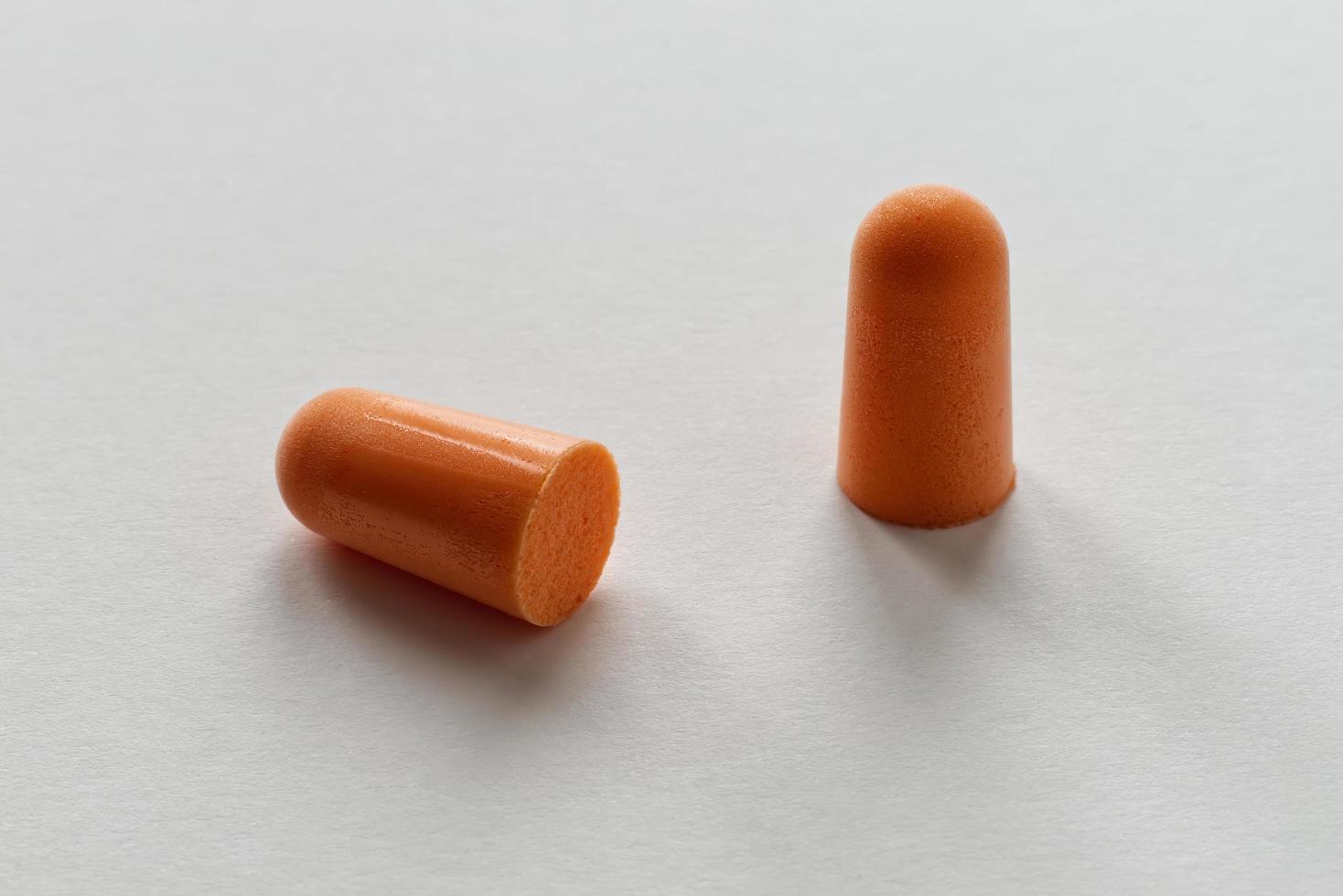 Orange foam ear plugs isolated on white background photo