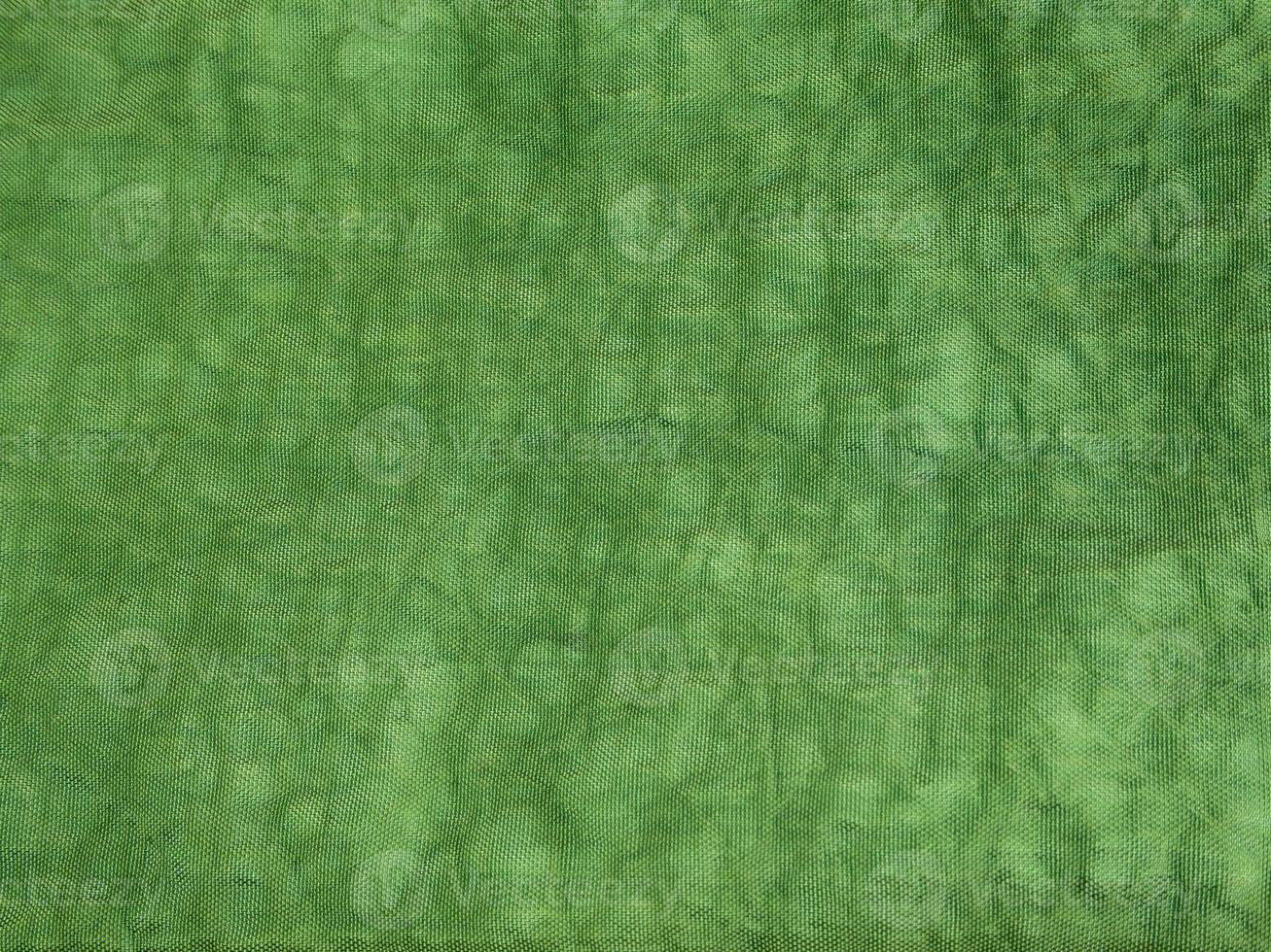 Surface texture of green color and crumpled canvas fabric photo