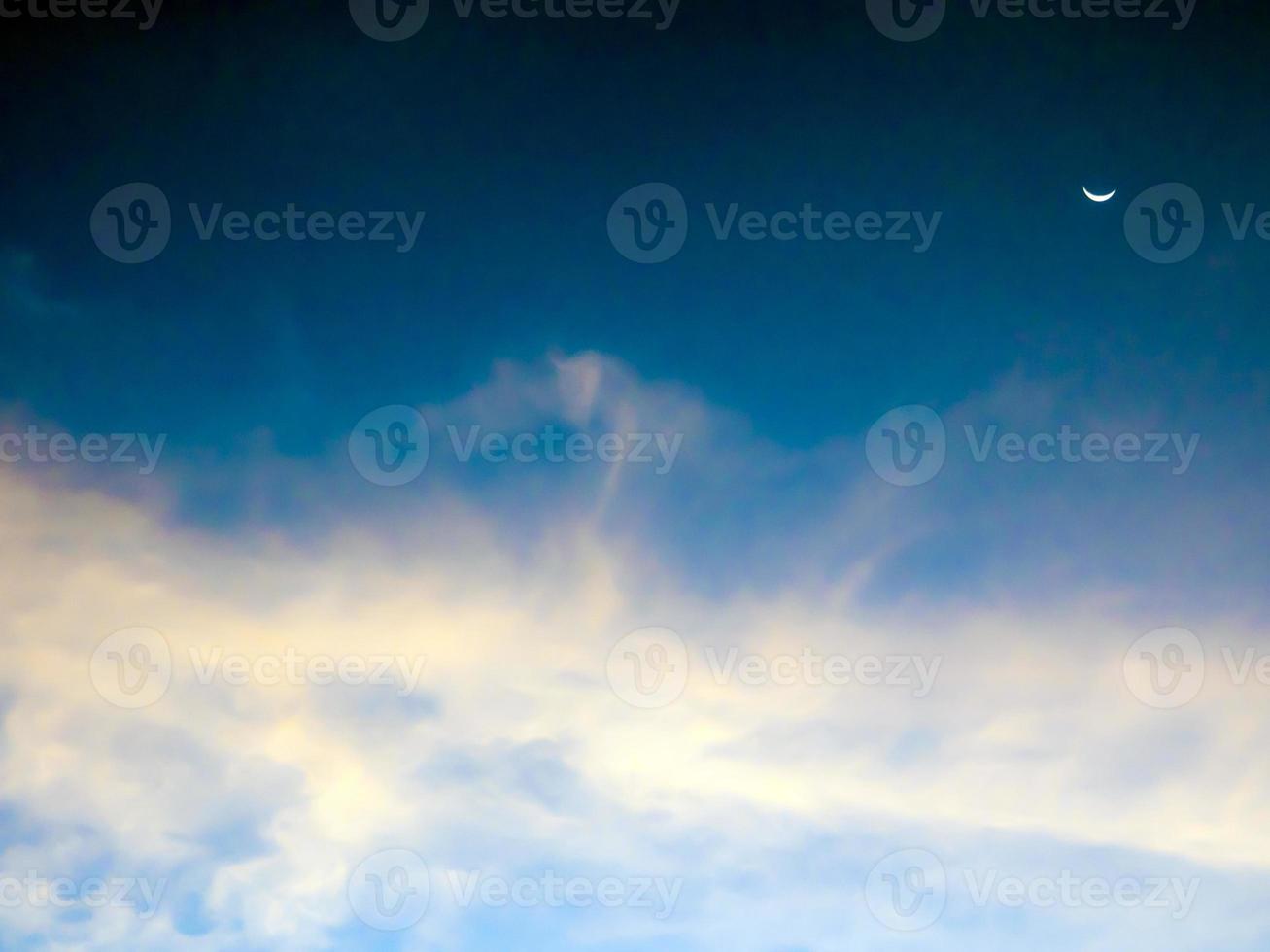 Crescent moon and clouds in the sky photo