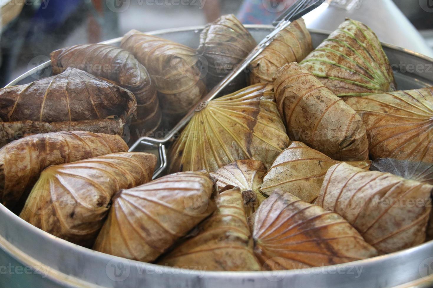 el arroz envuelto en hojas de loto está humeando en vapor, tailandia. foto