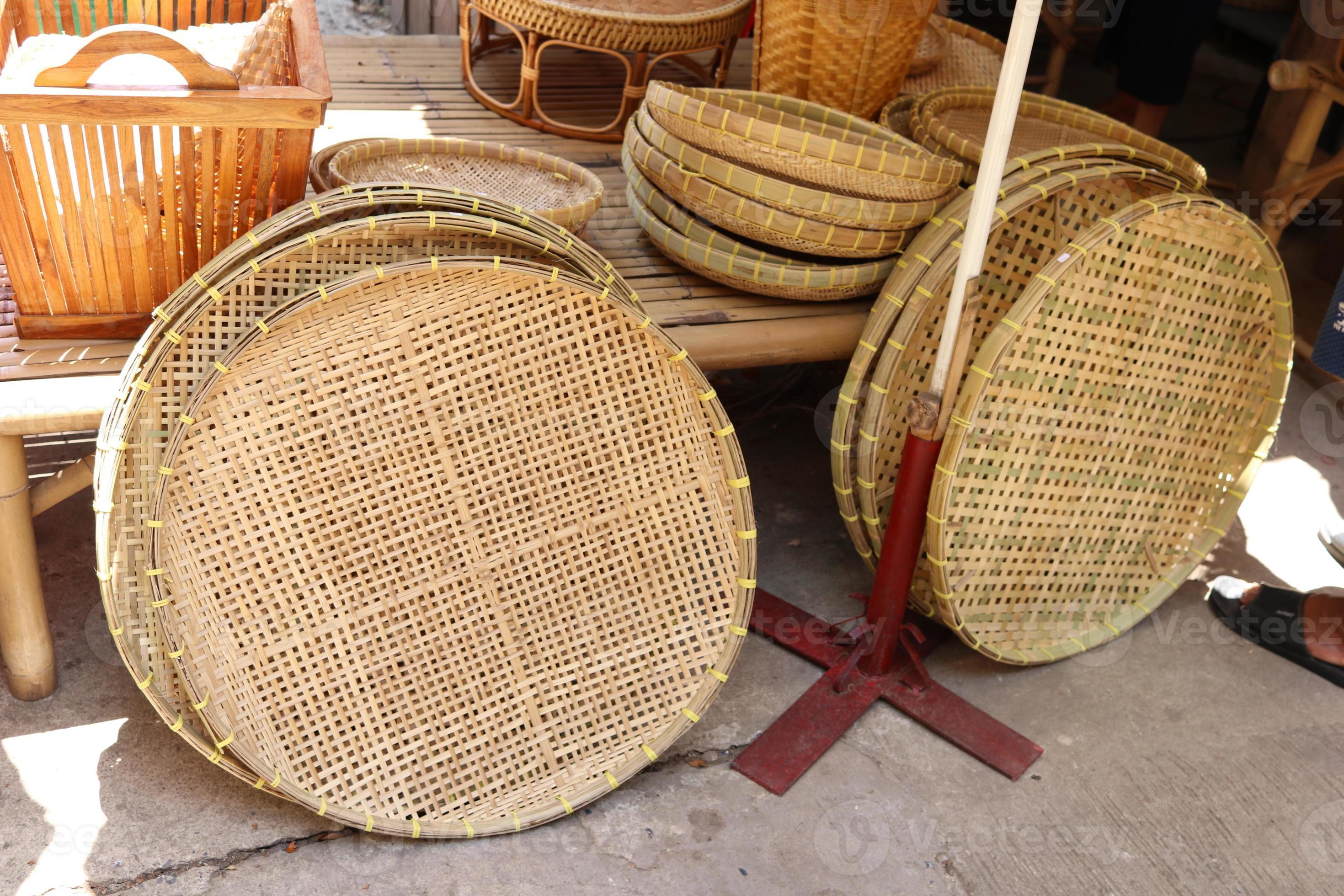 Rice winnowing basket or threshing basket are on floor beside bamboo