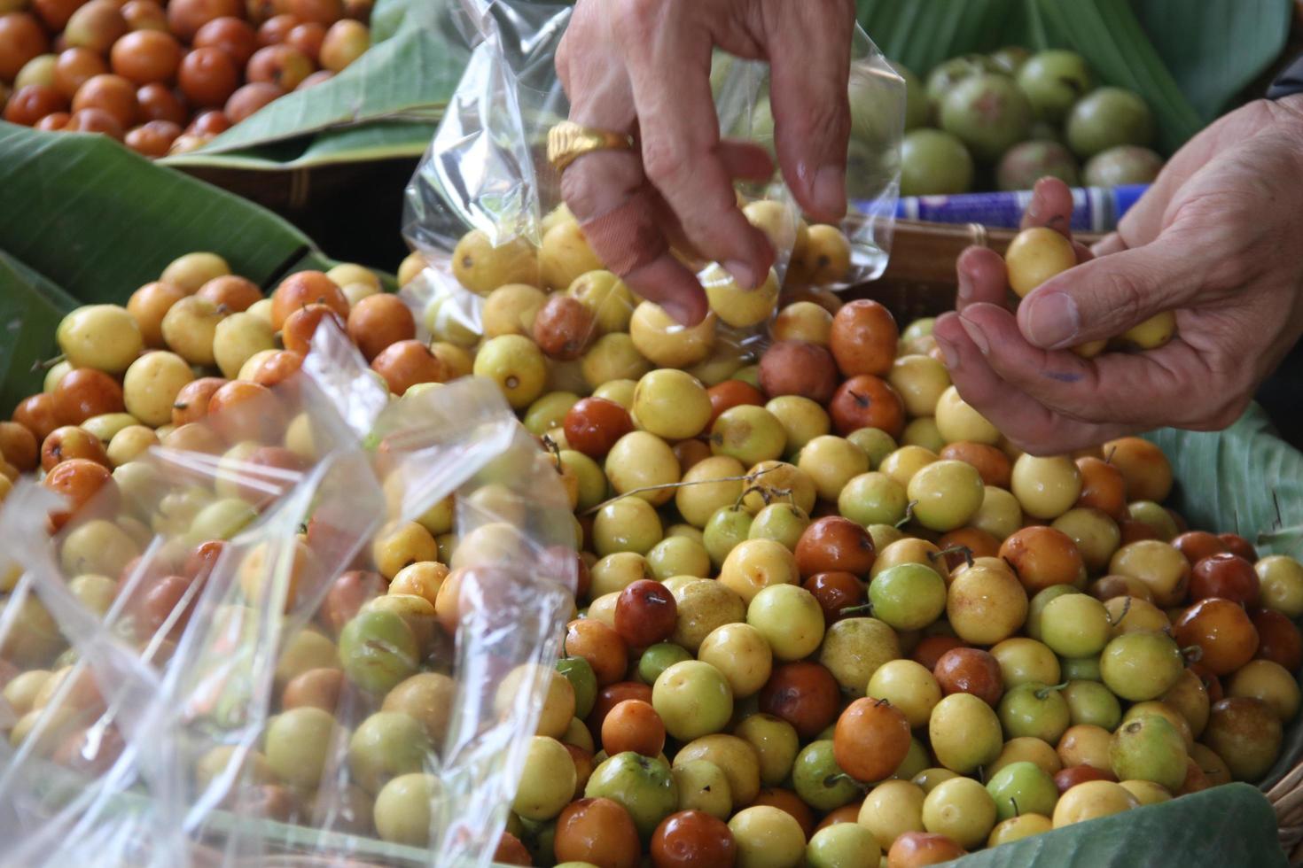 Hand is selecting Monkey Apples in basket. photo