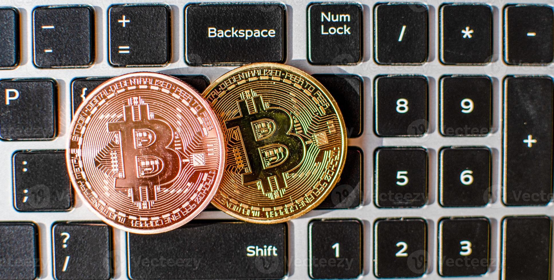 Two bitcoin placed on a laptop computer keyboard in the daytime. concept digital currency, Close-up, blurred background photo