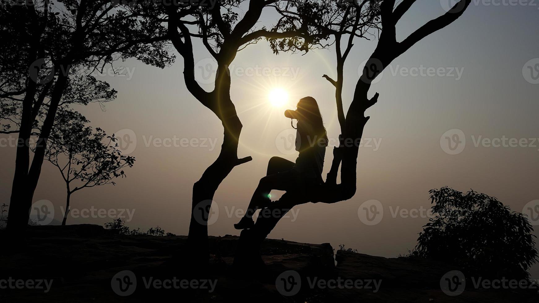 Women's silhouette at sunset on nature background. photo