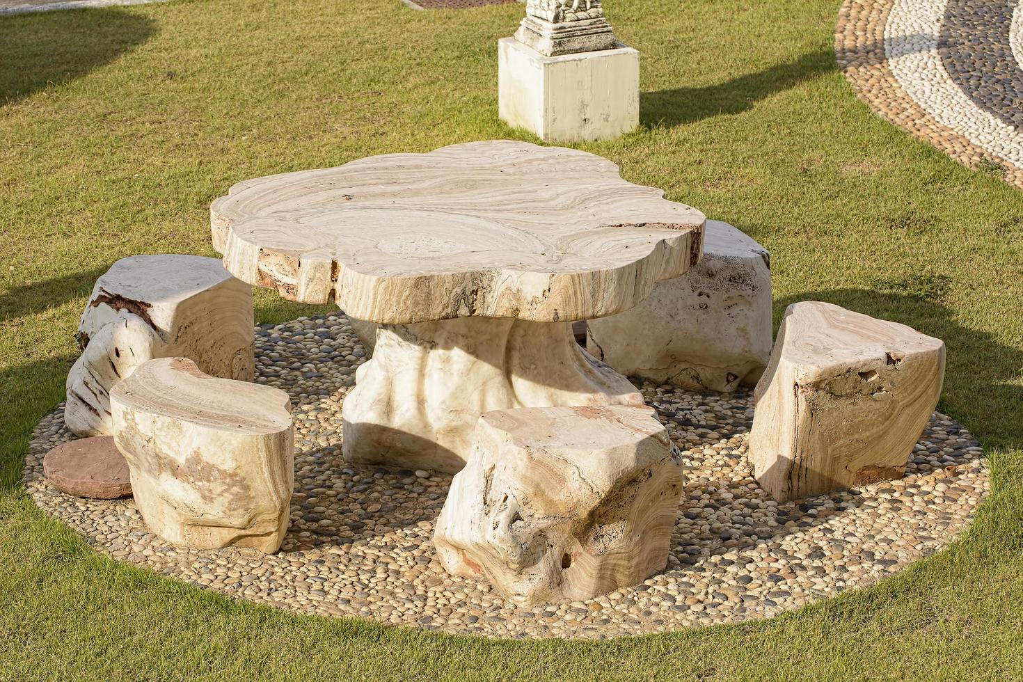 Marble table and chairs set on a nature background. photo