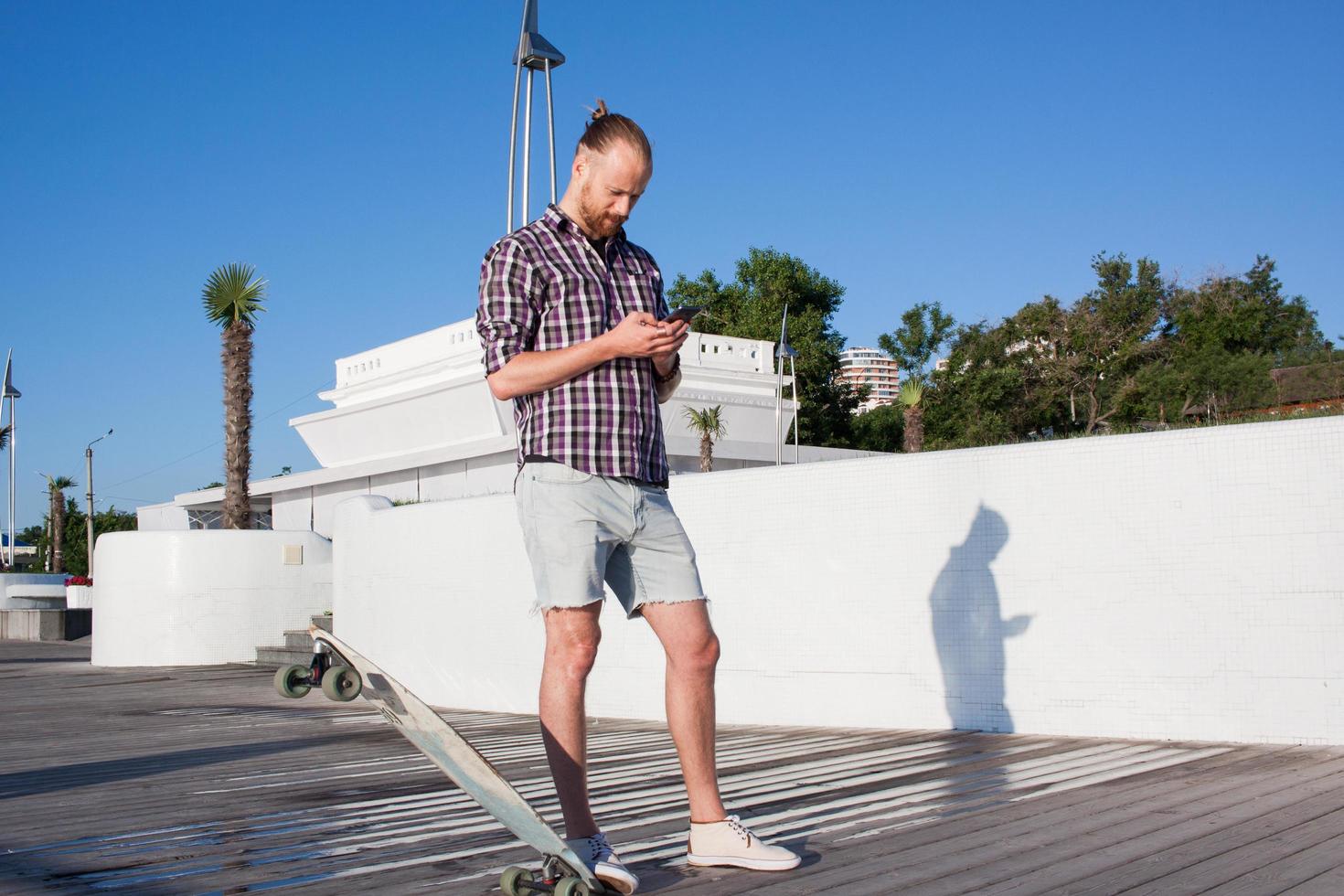 Young bearded skater on city beach photo