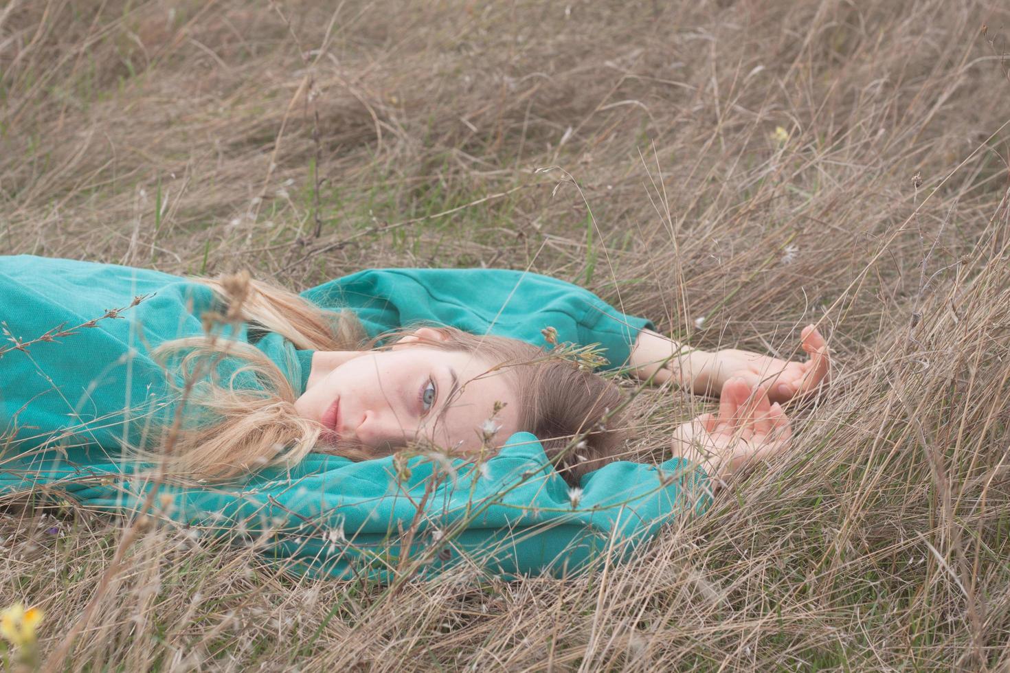 Young woman in fields, portrait of beautiful female relaxing in dry grass photo