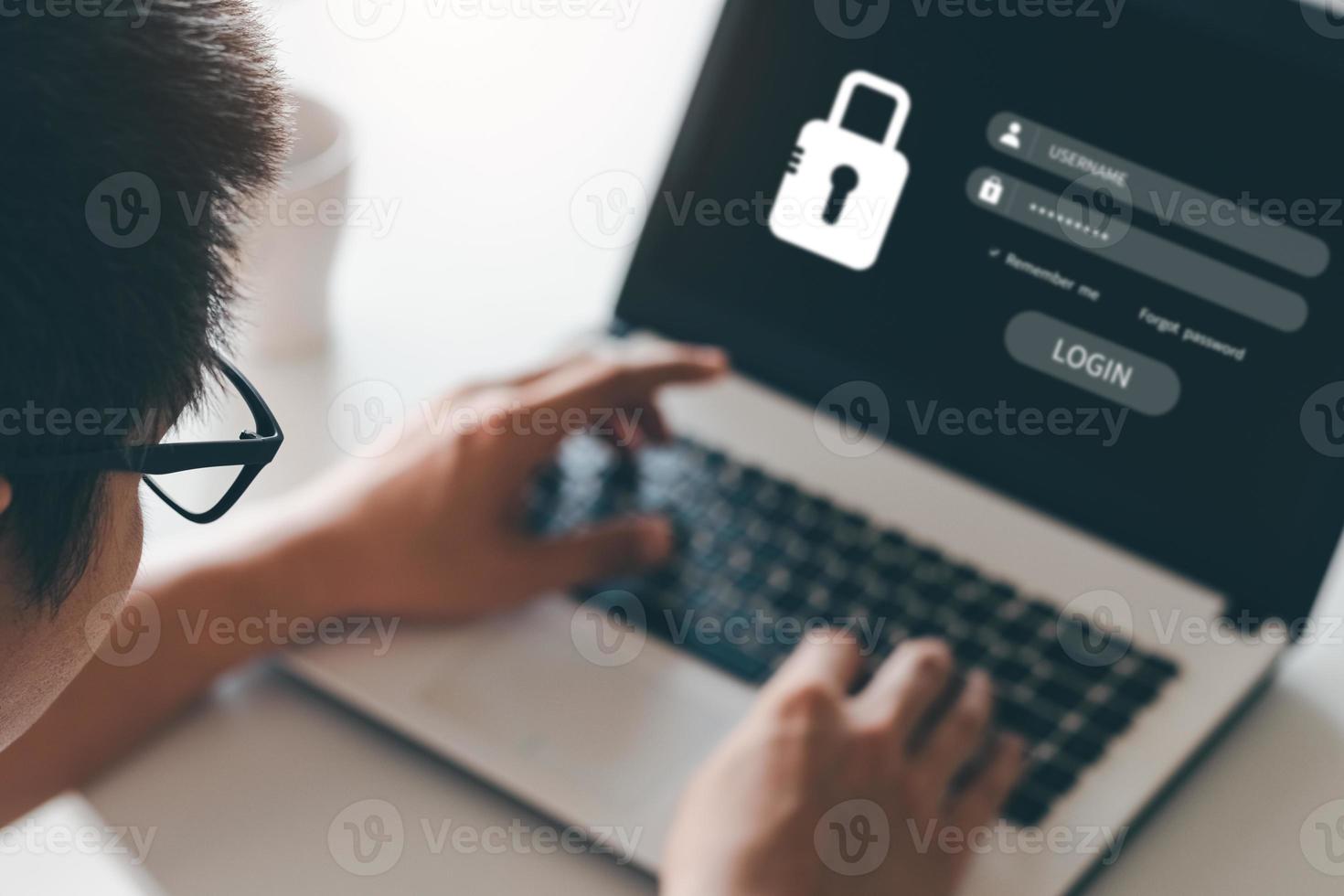 Hacking a Phishing mobile phone with a password to access a smartphone, security threats online, and fraud. A young man with a cell phone and laptop is secure in his bank account. photo