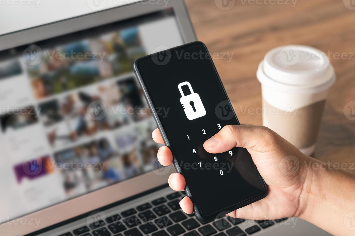 Hacking a Phishing mobile phone with a password to access a smartphone, security threats online, and fraud. A young man with a cell phone and laptop is secure in his bank account. photo