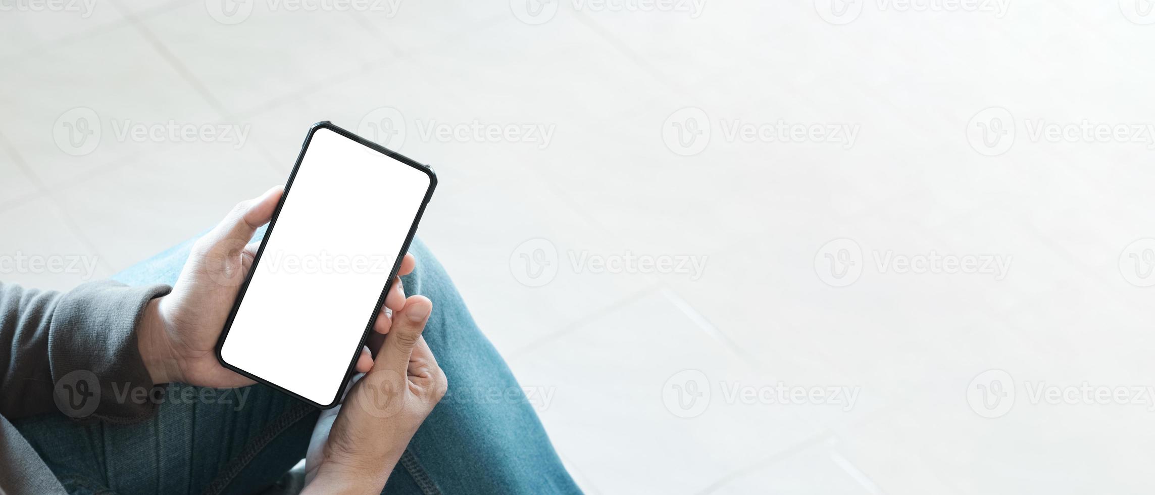 mockup copy space phone, man's hand holding smartphone with blank white copy screen for your advertising and message or information content, mobile on desk at coffee shop. photo