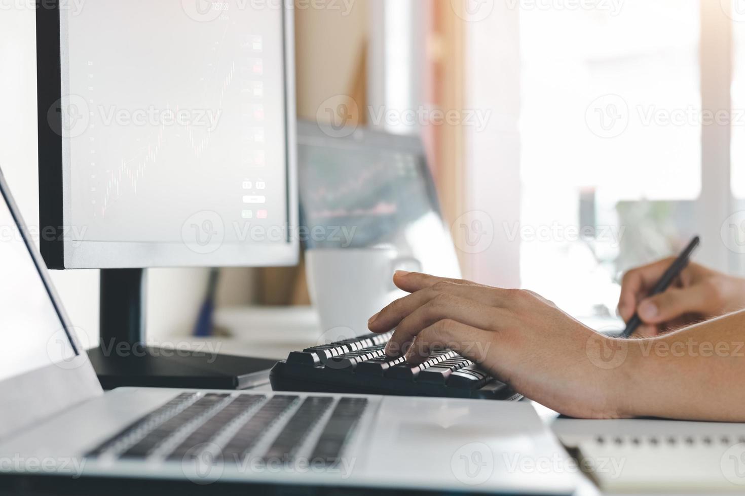 Businessmen work with stock market investments using laptops to analyze trading data. desktop computer with stock exchange graph on screen. Financial stock market. Analyzing data in office background. photo