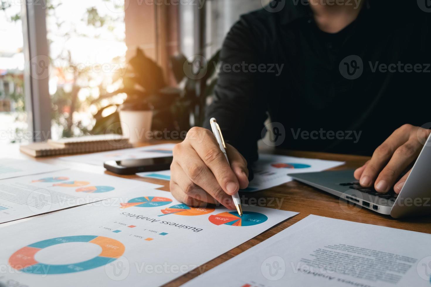 accounting concept. businessman working using a laptop with analyzing finance sales data and economic growth graph chart. at the coffee shop. photo