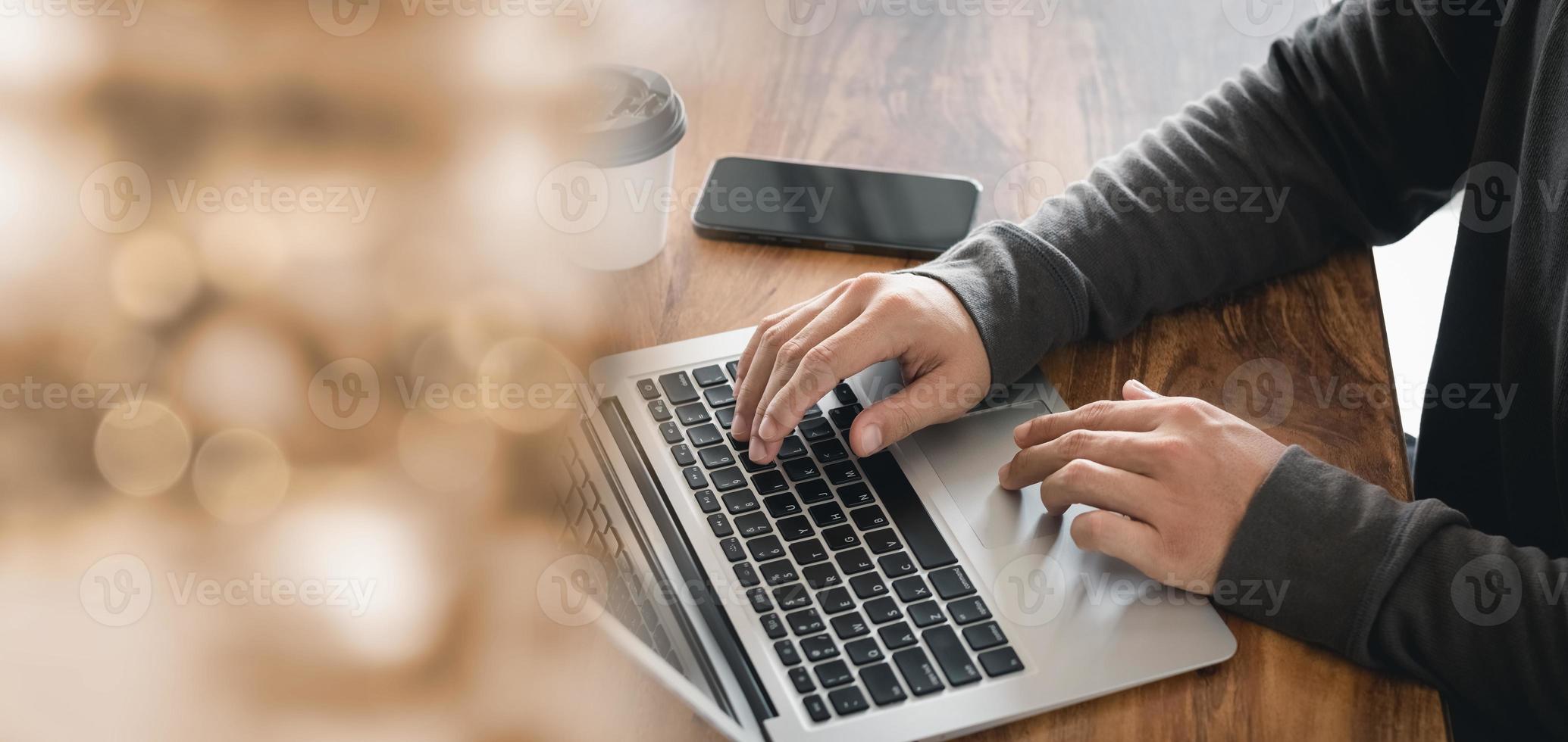 young man hand working on a laptop, bokeh blurred at natural For text copy space, image size horizontal. photo