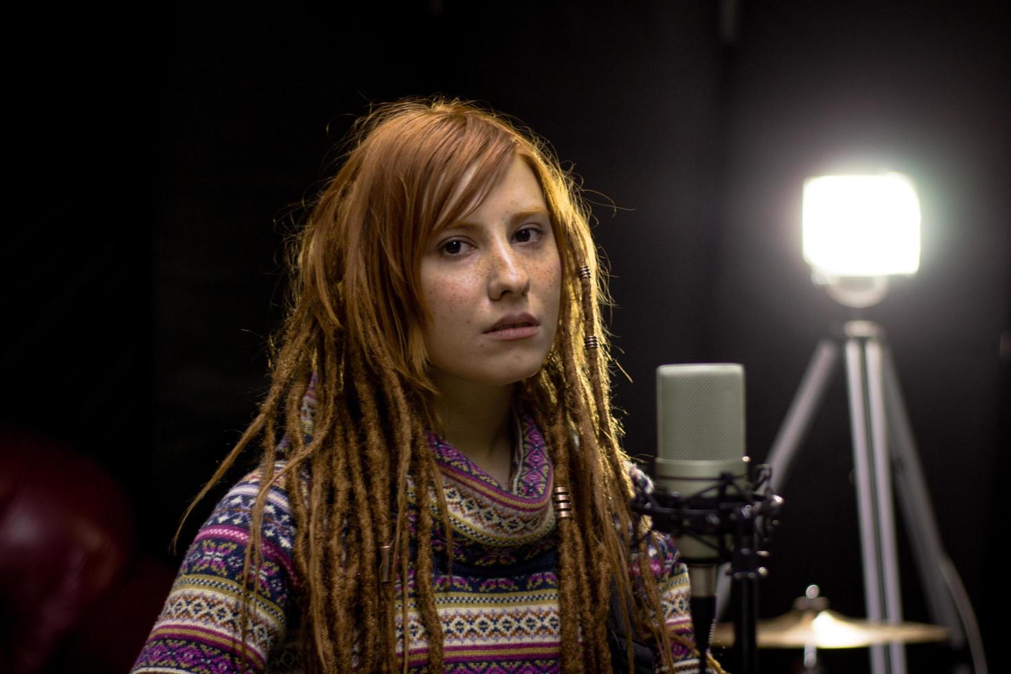 Young woman with guitar sing in the studio photo