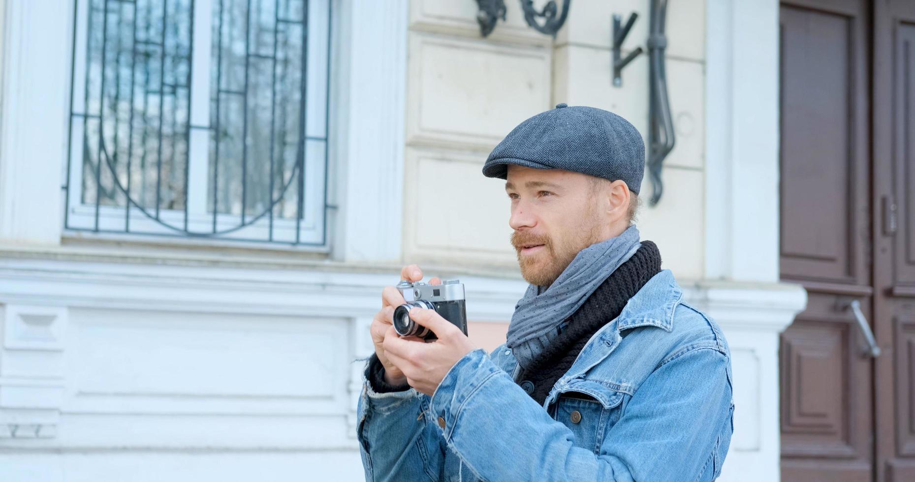 Young handsome male traveler with film camera do street photos