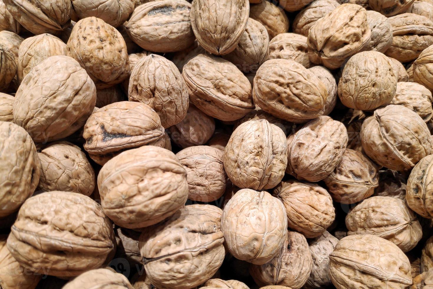 Stack of walnuts on a market stall photo