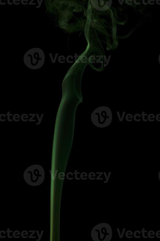 Green smoke swirling on a black background photo