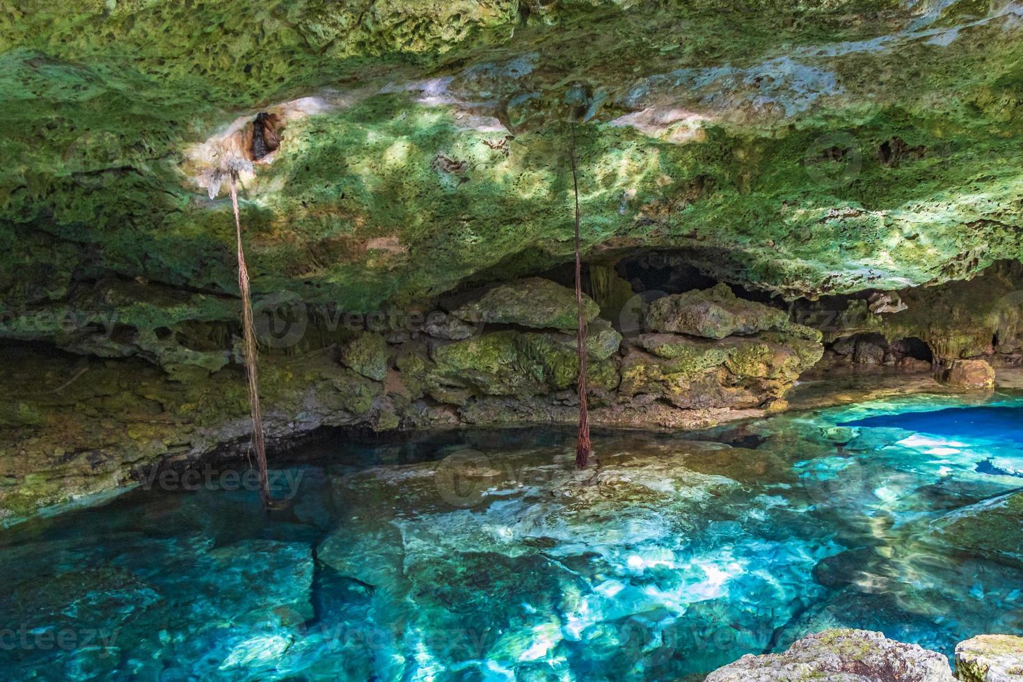 Blue turquoise water limestone cave sinkhole cenote Tajma ha Mexico. photo