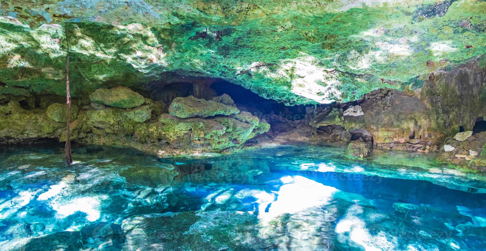 Blue turquoise water limestone cave sinkhole cenote Tajma ha Mexico. photo