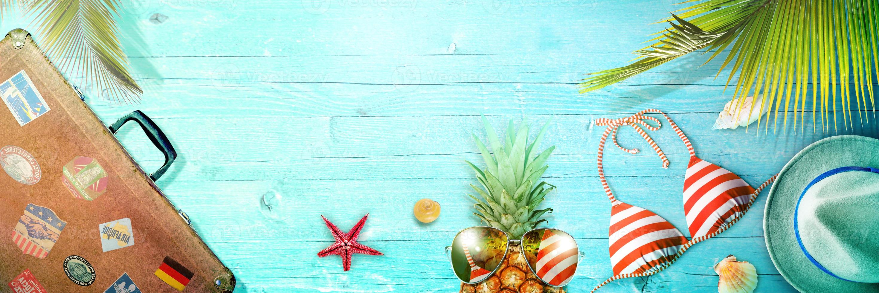 Nautical concept with palm leaf, beach hat, seashells and pineapple. photo