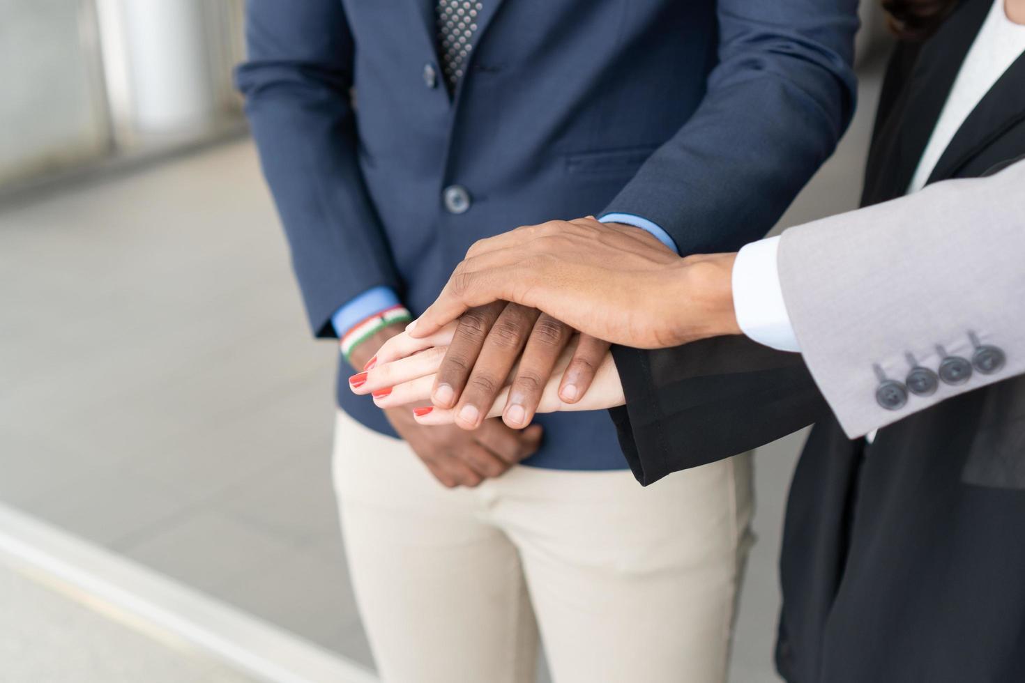 cerca de empresarios poniendo sus manos juntas. colegas de negocios que muestran unidad. éxito y concepto ganador foto