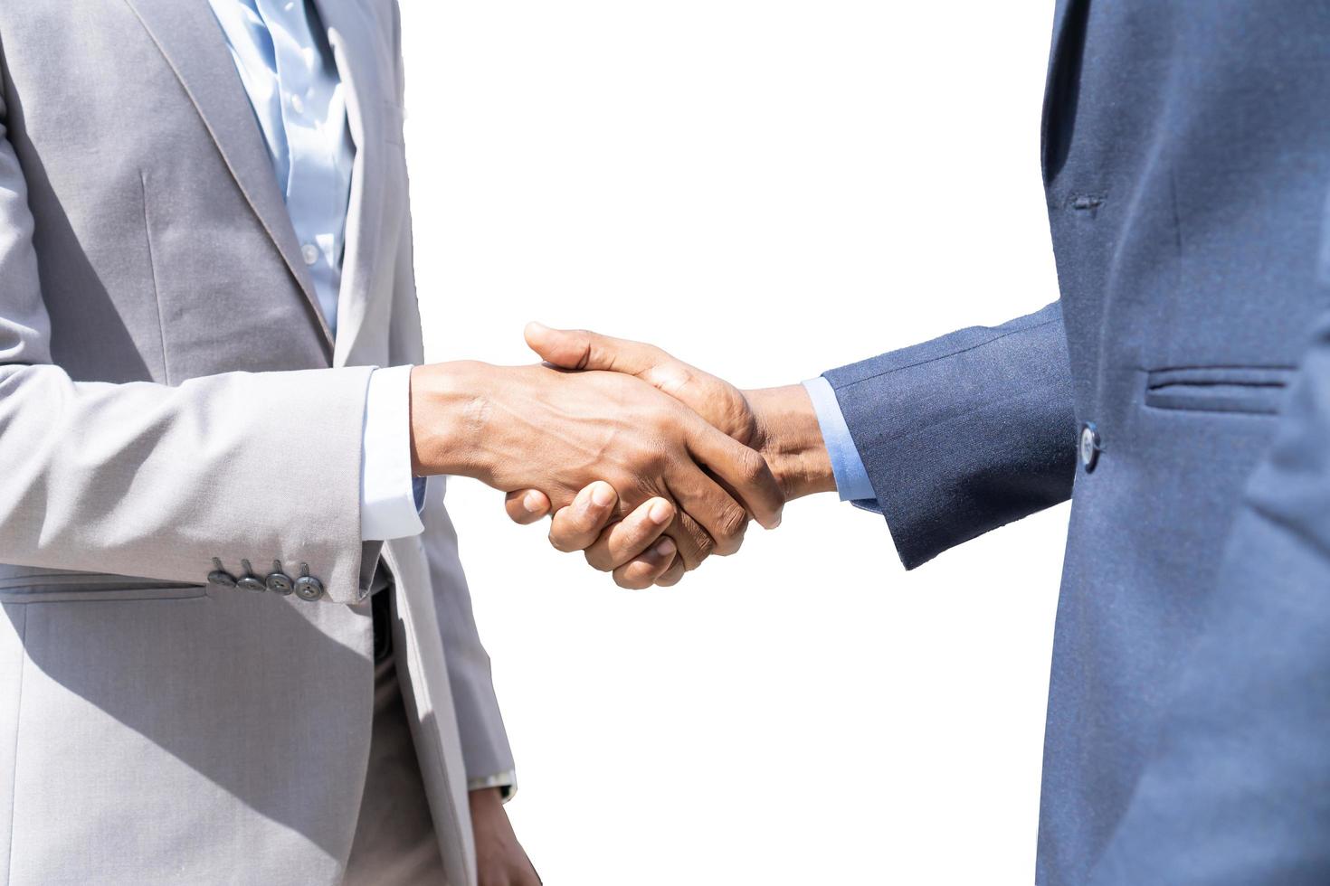 Businessmen shaking hands. Unknown businesspeople are shaking their hands after signing a contract, while standing together. photo