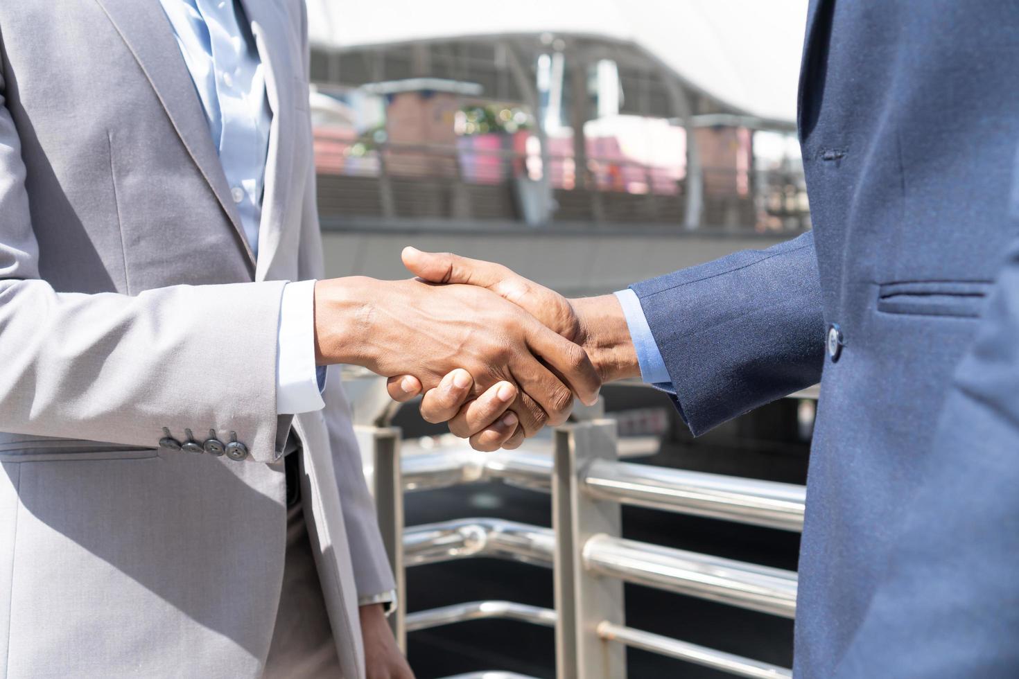 Businessmen shaking hands. Unknown businesspeople are shaking their hands after signing a contract, while standing together. photo