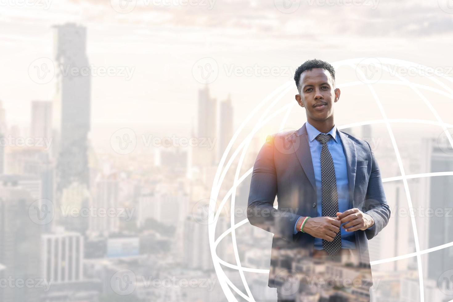 Business people in city. Portrait of an handsome businessman. Modern businessman. Confident young man in full suit and glasses while standing outdoors looking away with cityscape in the background photo