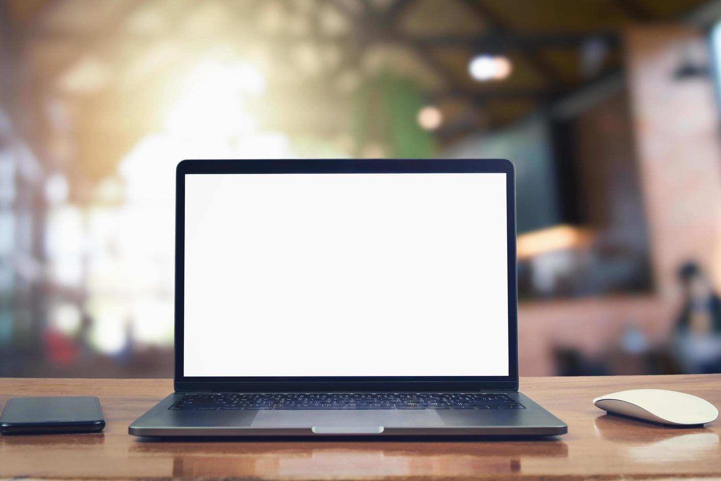 laptop computer blank white screen and mobile on table in cafe background photo