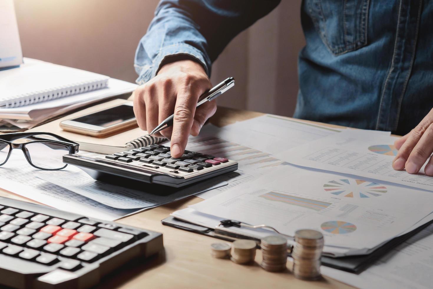 businessman working in office with using a calculator to calculate the numbers finance accounting concept photo