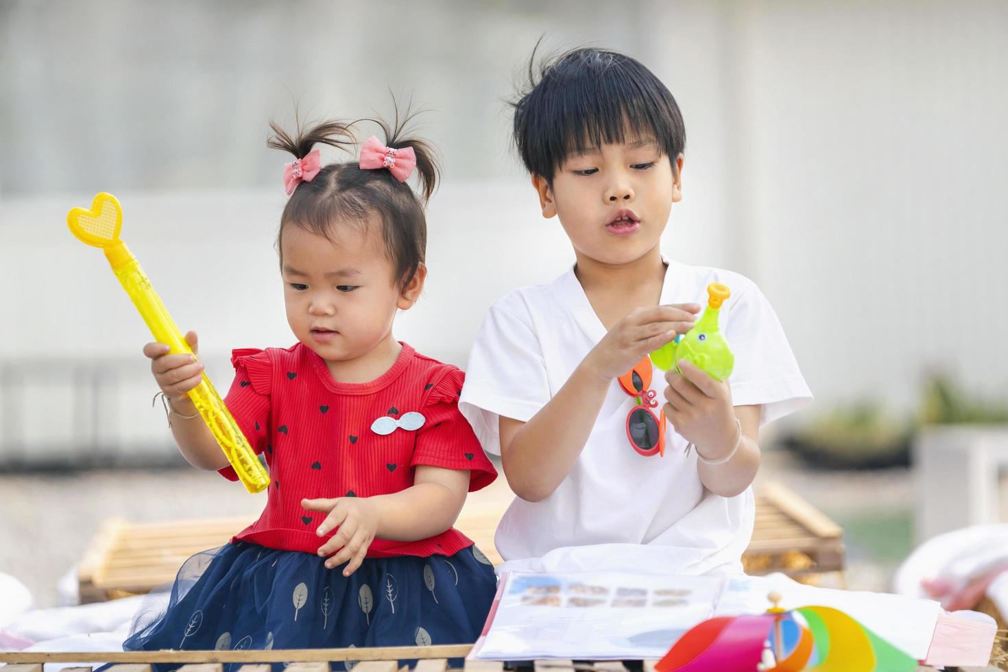 niña y niño asiáticos jugando con juguetes en casa foto