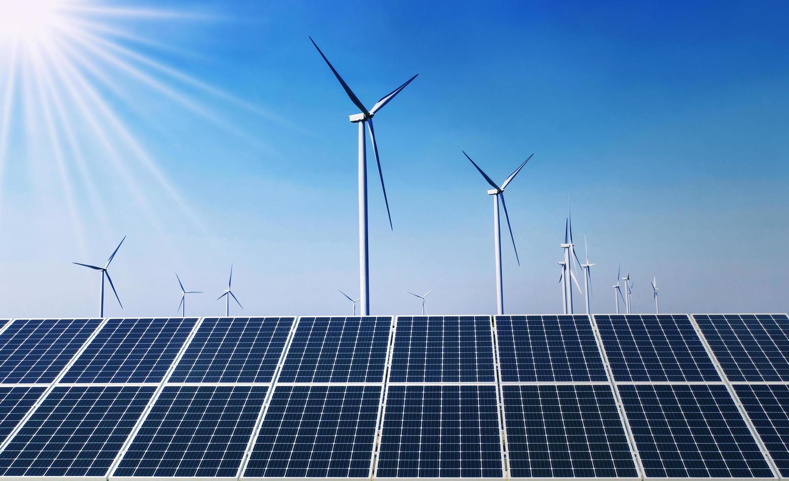 concept clean energy power in nature. solar panel with wind turbine and blue sky background photo