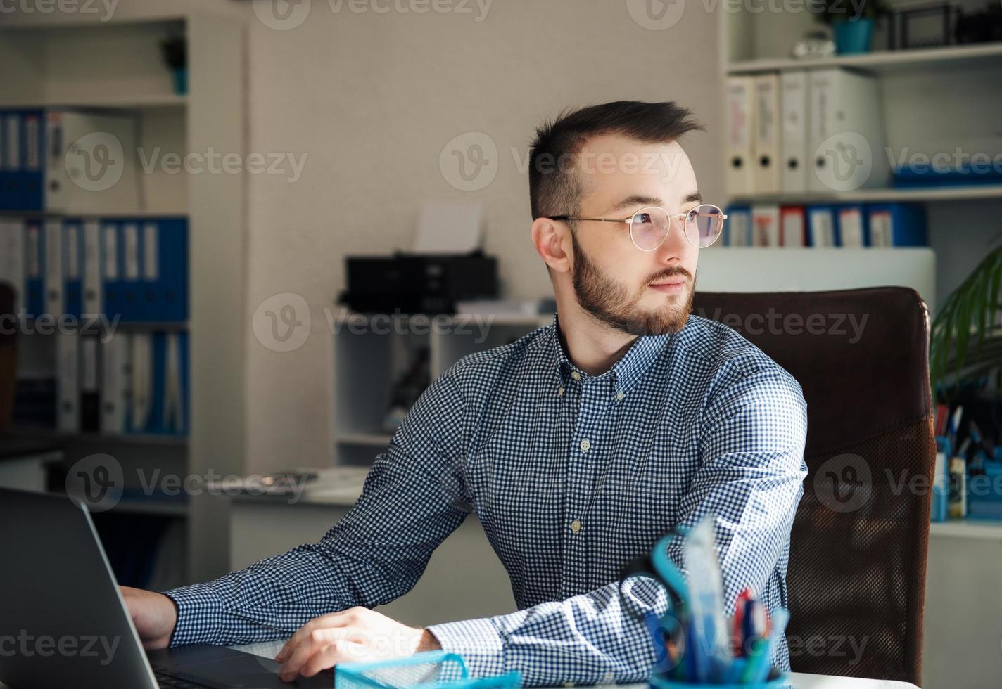 Businessman working on his laptop in an office photo